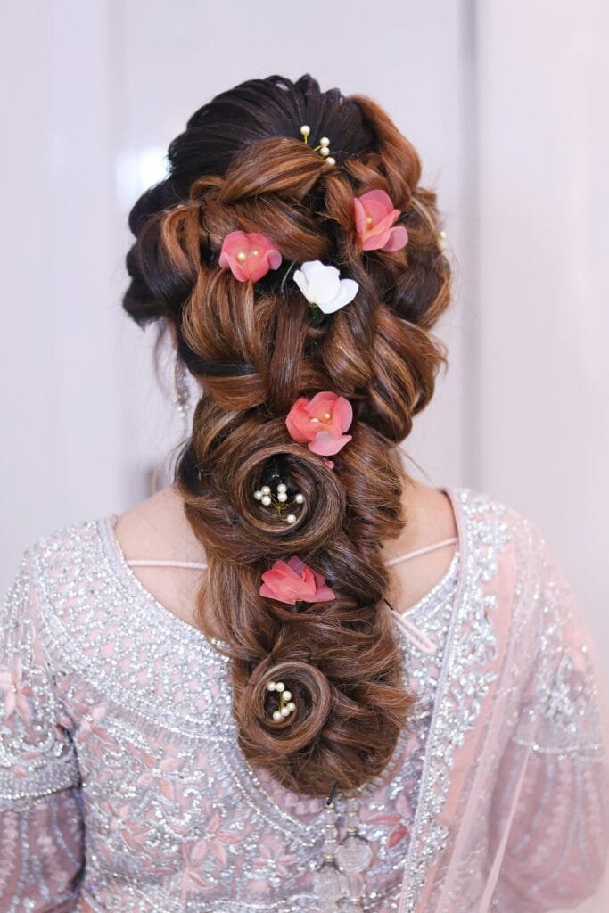 Stunning elegant braid adorned with pink and white flowers, perfect for bridal looks.